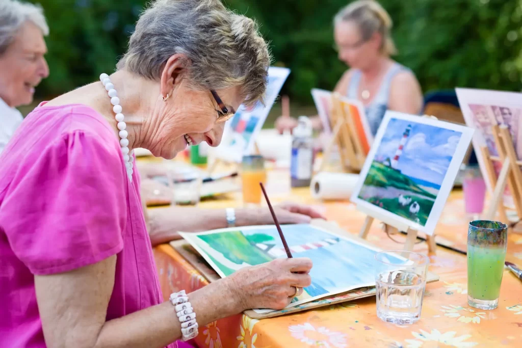 Elderly woman painting at a Senior Independent Living